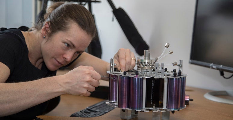 A scientist works on an instrument
